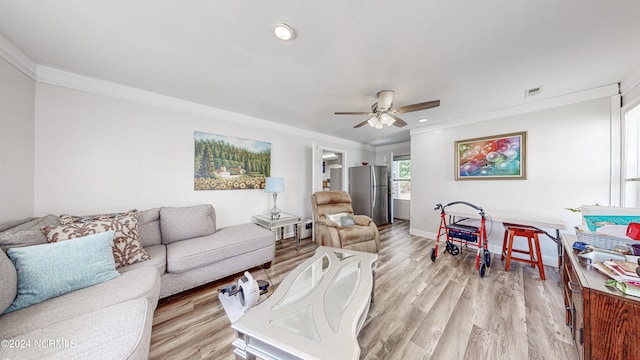 living room featuring crown molding, light hardwood / wood-style flooring, and ceiling fan