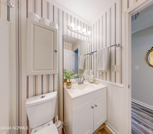 bathroom with vanity, toilet, wood-type flooring, and crown molding