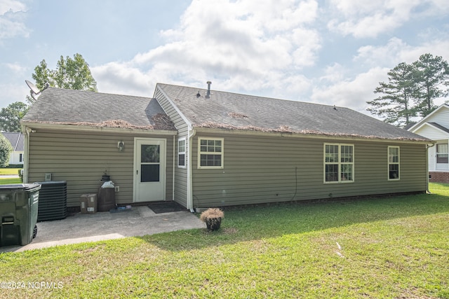 rear view of house featuring a patio, central AC, and a yard