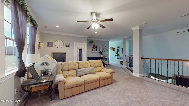 carpeted living room featuring crown molding, ceiling fan, and ornate columns