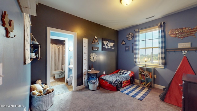 bedroom featuring ensuite bath and carpet floors