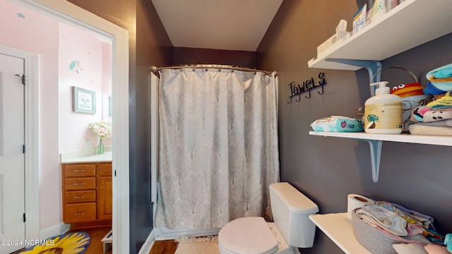 bathroom featuring walk in shower, vanity, and toilet