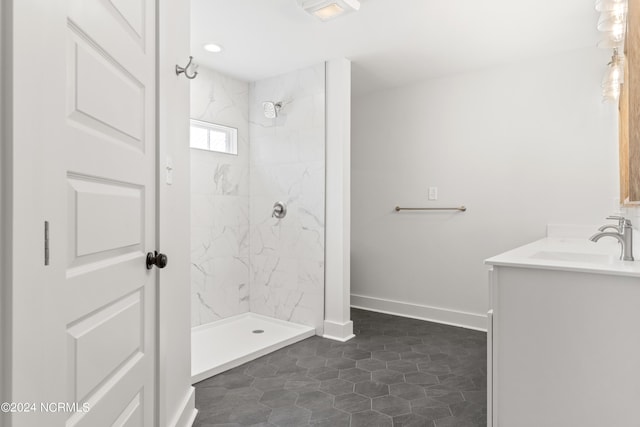 bathroom featuring tiled shower, vanity, and tile patterned flooring