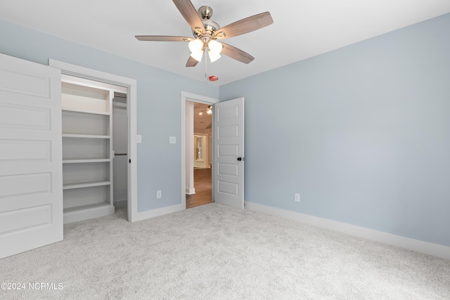 unfurnished bedroom featuring light carpet, a closet, and ceiling fan