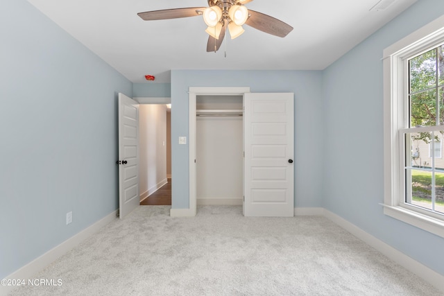 unfurnished bedroom with ceiling fan, light colored carpet, and a closet