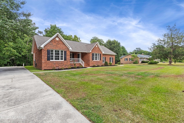 single story home featuring a front lawn and covered porch