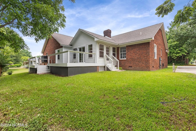 back of house featuring a deck and a yard