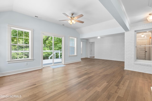 unfurnished living room with hardwood / wood-style floors, ceiling fan, brick wall, and vaulted ceiling