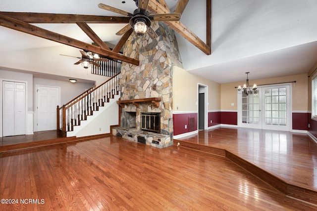 unfurnished living room featuring ceiling fan with notable chandelier, beam ceiling, hardwood / wood-style flooring, and high vaulted ceiling