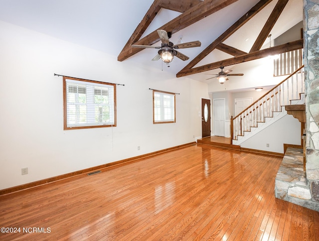 unfurnished living room featuring light wood-style floors, high vaulted ceiling, a ceiling fan, baseboards, and visible vents