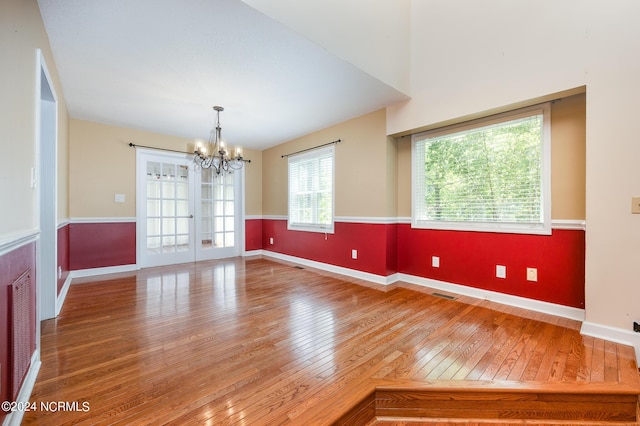 unfurnished dining area with an inviting chandelier, light wood-style flooring, baseboards, and visible vents