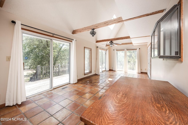 unfurnished living room featuring plenty of natural light, tile patterned floors, a skylight, and beamed ceiling