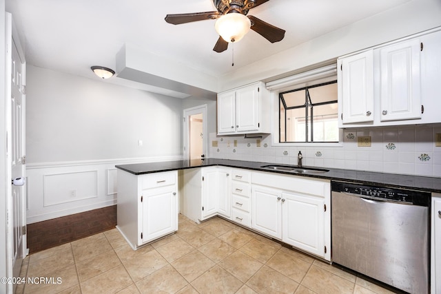 kitchen with a sink, a peninsula, dishwasher, and dark countertops