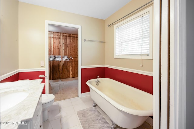 bathroom with vanity, tile patterned floors, a freestanding bath, and toilet