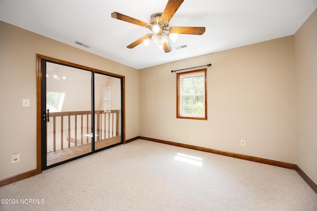 carpeted empty room featuring baseboards, visible vents, and ceiling fan
