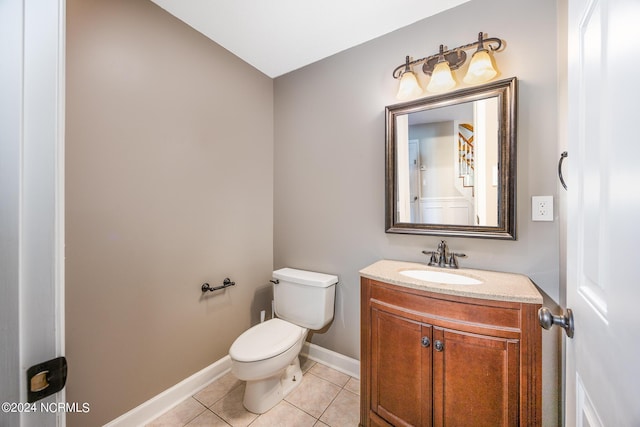 half bath with vanity, baseboards, tile patterned floors, and toilet
