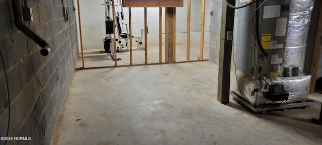 unfinished basement featuring concrete block wall