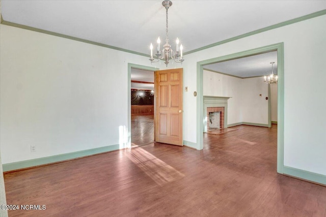 unfurnished dining area featuring ornamental molding, a brick fireplace, and hardwood / wood-style floors