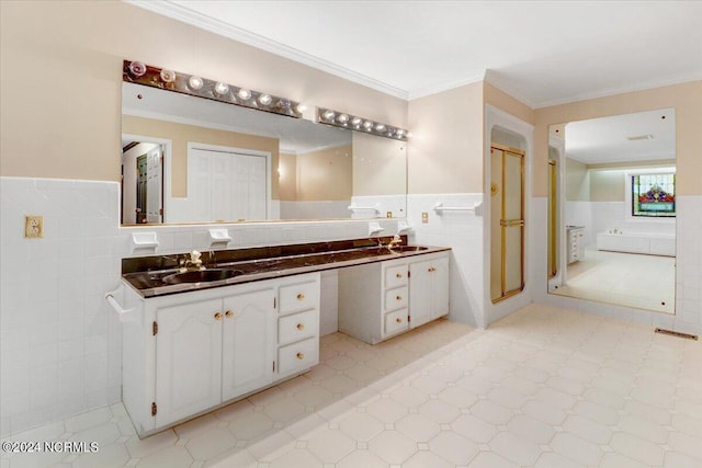 bathroom featuring a shower with door, ornamental molding, tile walls, and vanity