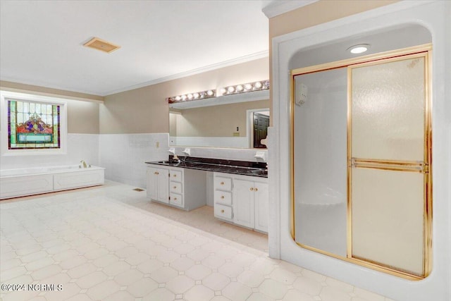 bathroom with independent shower and bath, vanity, tile walls, and crown molding