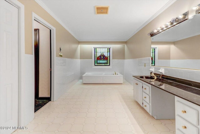 bathroom featuring ornamental molding, a bathing tub, tile walls, and vanity