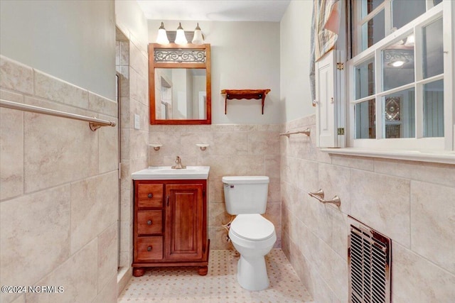 bathroom with heating unit, tile walls, tile patterned flooring, vanity, and toilet