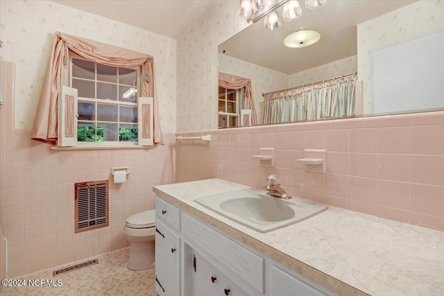 bathroom with vanity, tile walls, a shower with shower curtain, and toilet