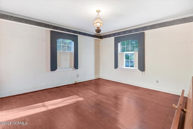 empty room featuring hardwood / wood-style floors and crown molding