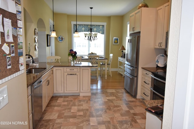 kitchen with pendant lighting, an inviting chandelier, sink, kitchen peninsula, and stainless steel appliances