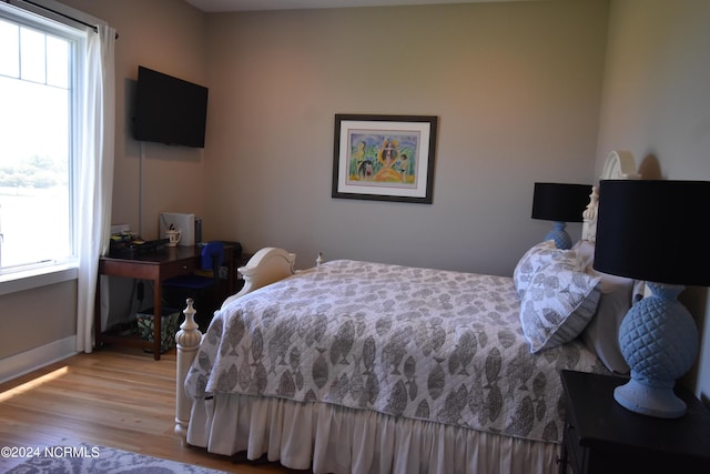 bedroom with light hardwood / wood-style floors and multiple windows