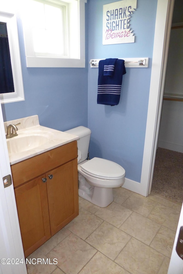 bathroom featuring tile patterned flooring, vanity, and toilet