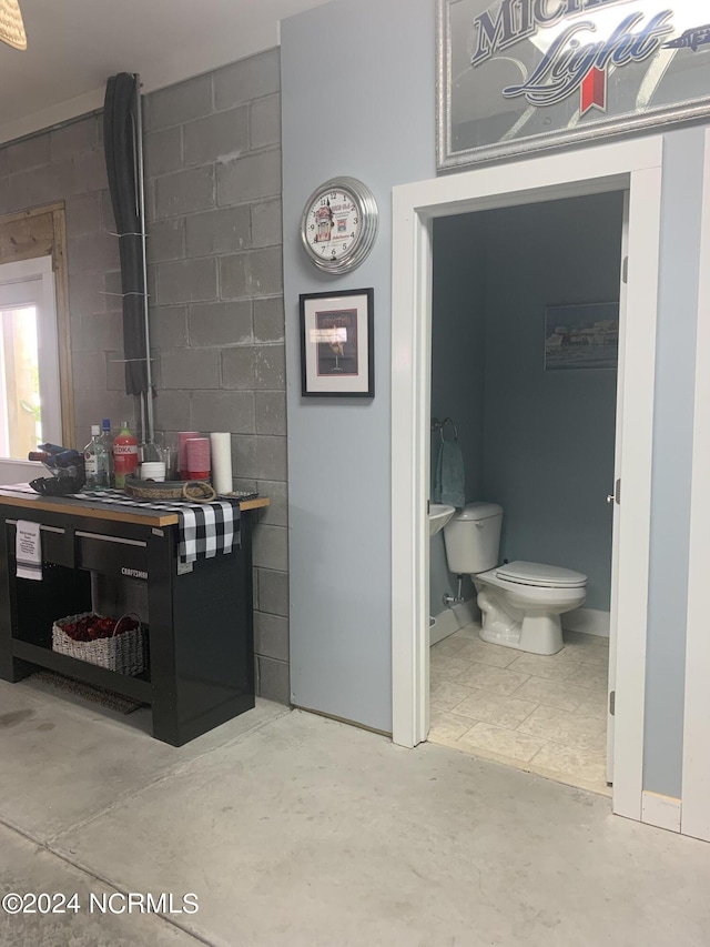 bathroom featuring toilet and concrete floors