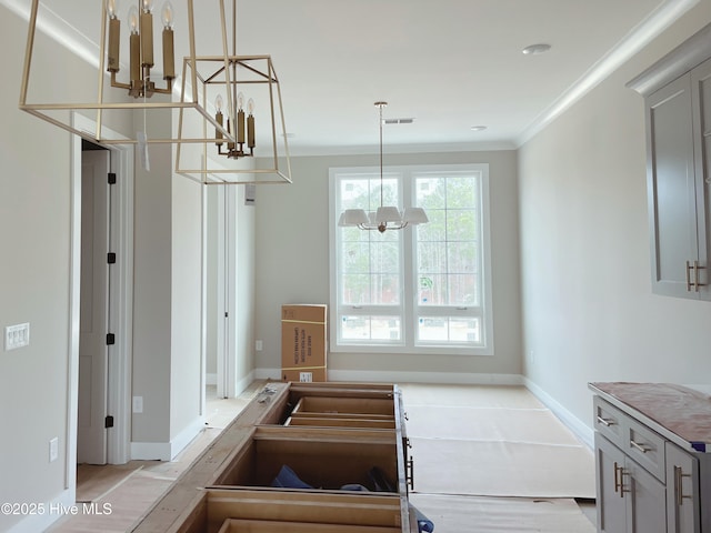 kitchen with pendant lighting, a notable chandelier, and ornamental molding