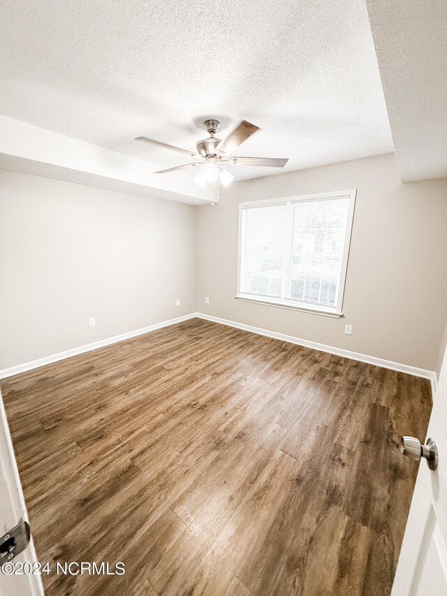 unfurnished room with a textured ceiling, hardwood / wood-style flooring, and ceiling fan