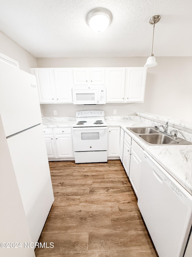 kitchen with light hardwood / wood-style flooring, hanging light fixtures, sink, white cabinetry, and white appliances