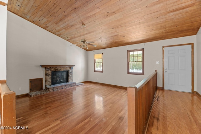 unfurnished living room with a fireplace, lofted ceiling, ceiling fan, light hardwood / wood-style floors, and wooden ceiling