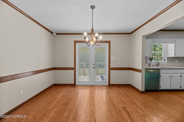 unfurnished dining area with french doors, sink, light hardwood / wood-style floors, and a textured ceiling