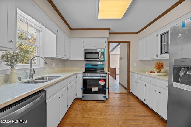 kitchen with stainless steel appliances, sink, and white cabinets