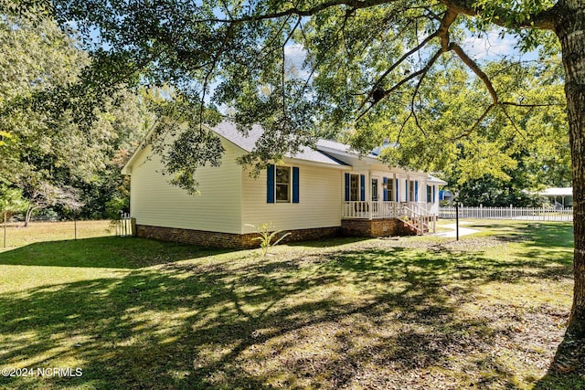 back of property featuring fence and a yard