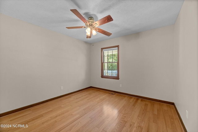 unfurnished room featuring ceiling fan, light hardwood / wood-style floors, and a textured ceiling