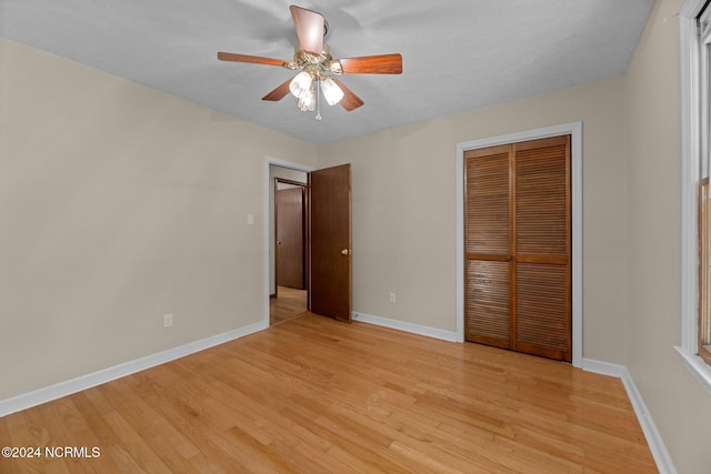 unfurnished bedroom with ceiling fan, light hardwood / wood-style floors, and a closet