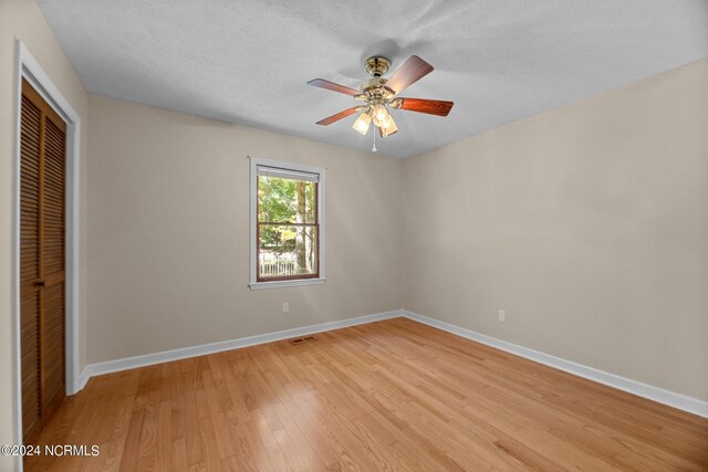 unfurnished bedroom featuring a closet, ceiling fan, and light wood-type flooring