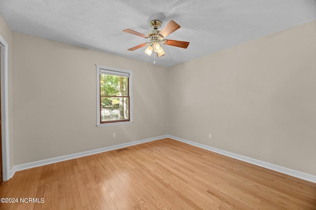 empty room featuring ceiling fan, light hardwood / wood-style floors, and a textured ceiling