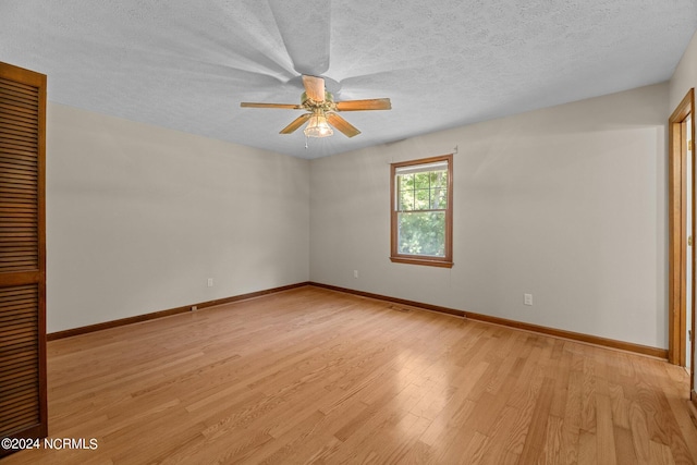 spare room with ceiling fan, light hardwood / wood-style floors, and a textured ceiling