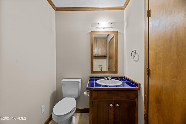 bathroom with vanity, ornamental molding, and toilet