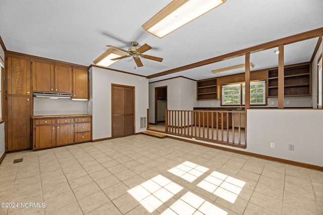 interior space with ornamental molding, ceiling fan, and light tile patterned flooring