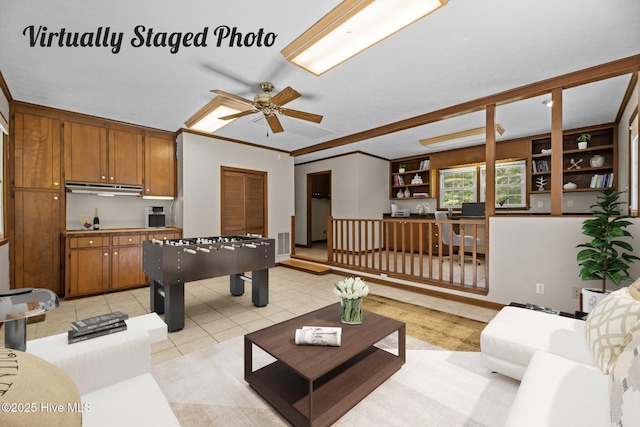 rec room with crown molding, ceiling fan, and light tile patterned flooring