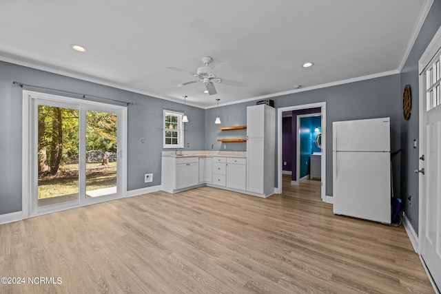 kitchen with white refrigerator, sink, white cabinets, and light hardwood / wood-style floors