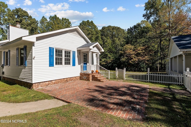 bungalow featuring a chimney, fence, and a front yard