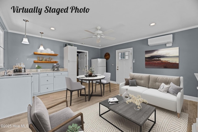 living room with sink, a wall mounted air conditioner, light wood-type flooring, ornamental molding, and ceiling fan